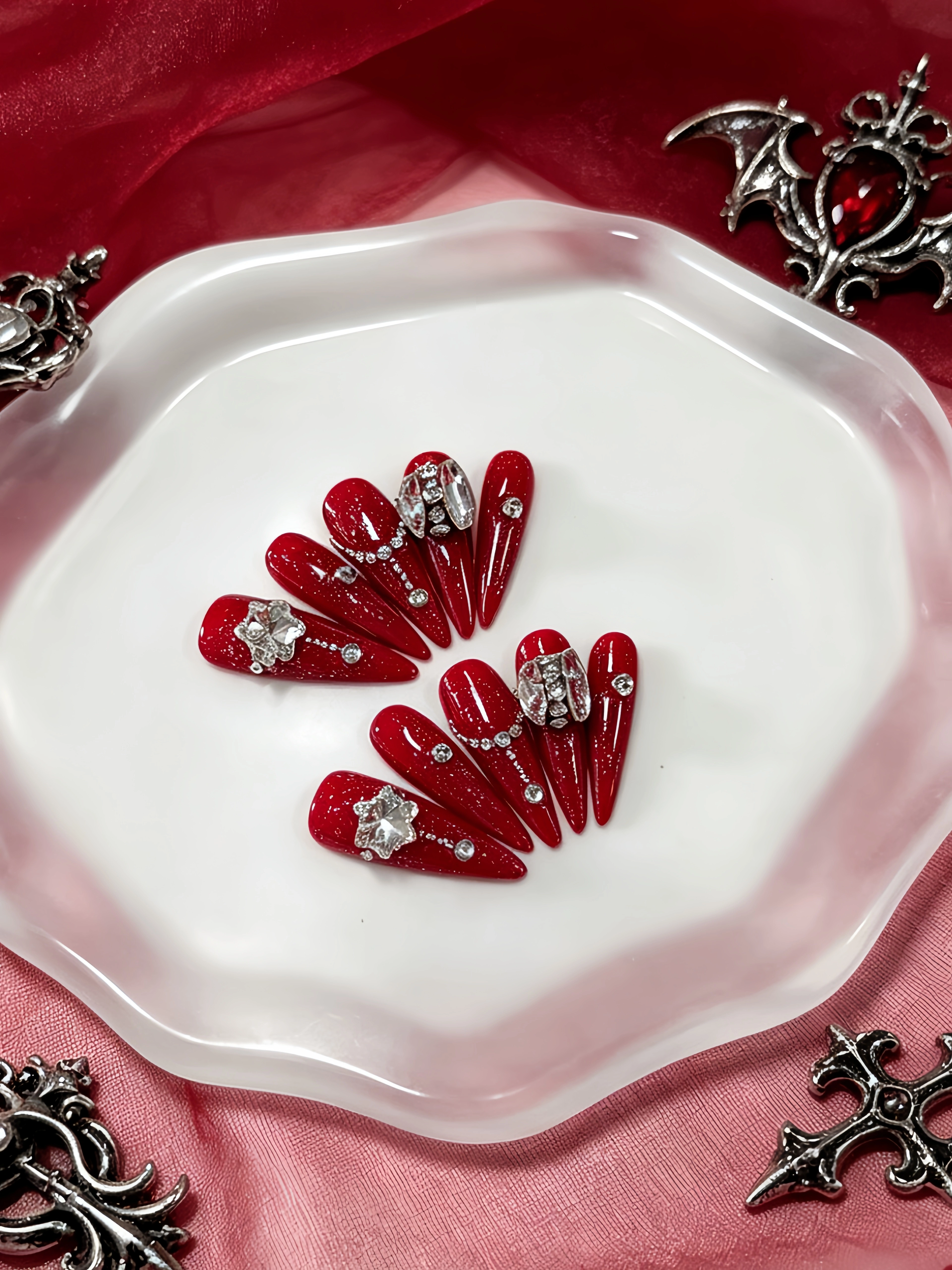 10 faux ongles longs en forme de larme, avec une base rouge pailletée, décorés de strass en forme de