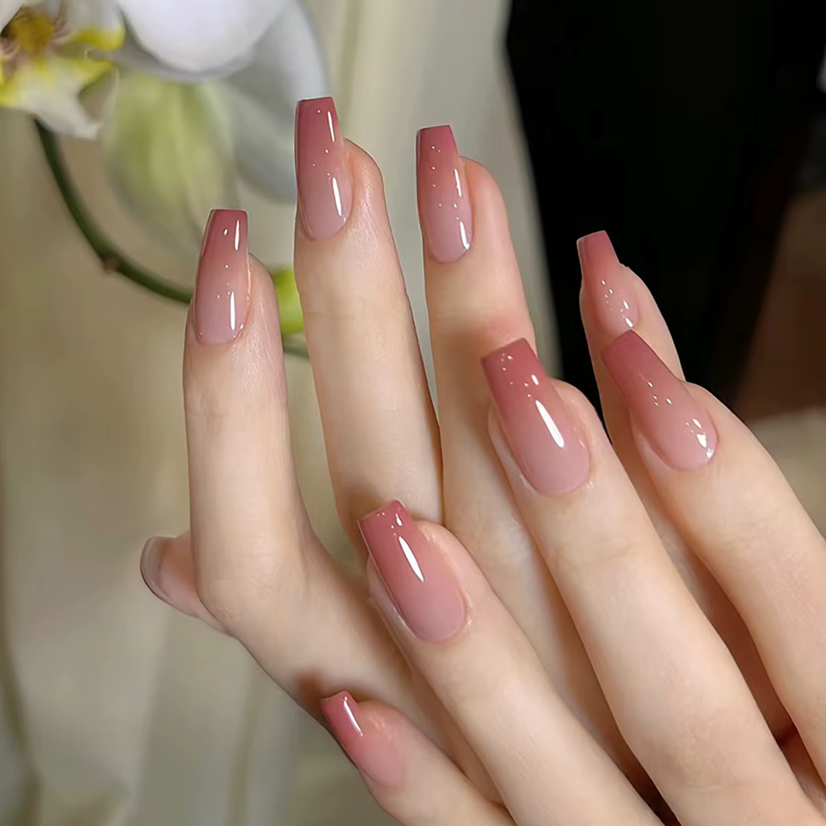 Un ensemble complet de 24 faux ongles moyens en forme de cercueil avec un design dégradé pêche, comp