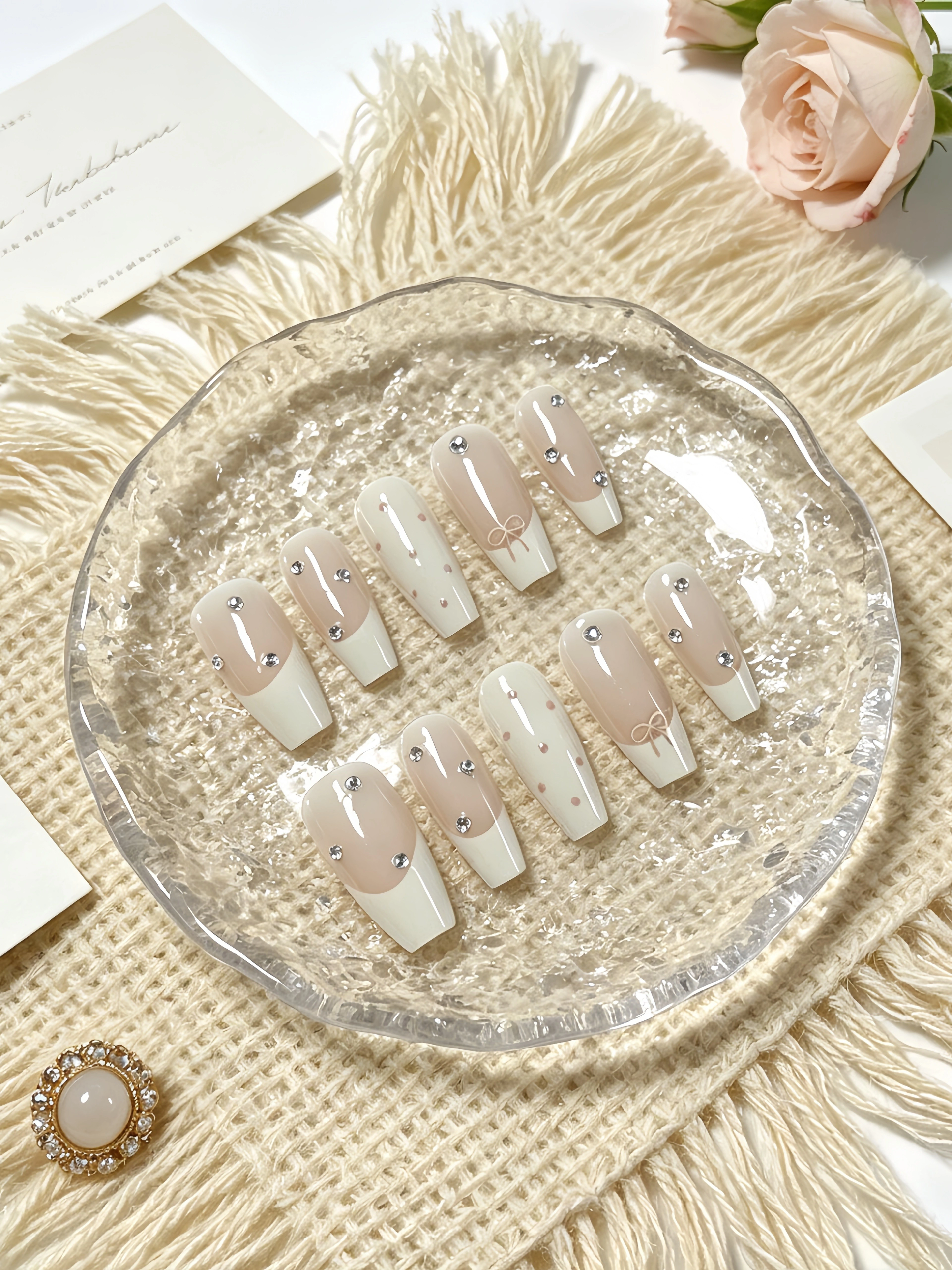 10 faux ongles trapézoïdaux de longueur moyenne, principalement en blanc laiteux et rose nude, avec 