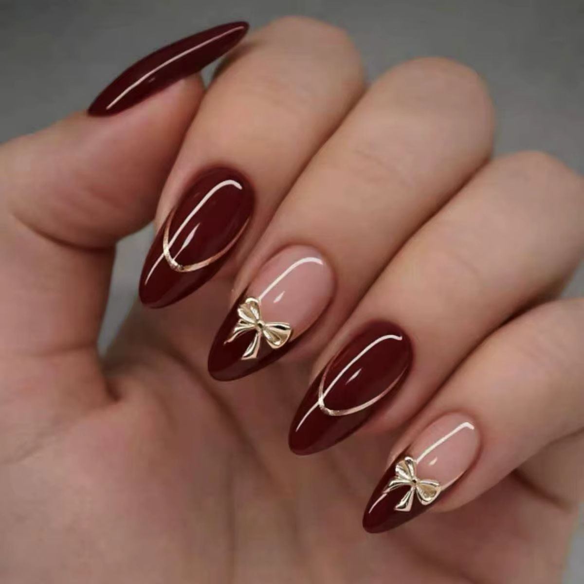 24 ongles d'amande faits à la main. Base bordeaux avec détails français nude, lignes blanches et nœu