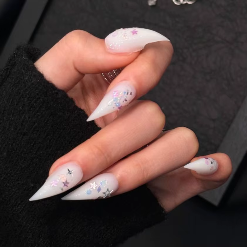 Faux ongles longs stiletto blanc laiteux à presser, avec paillettes étoiles irisées et breloques éto