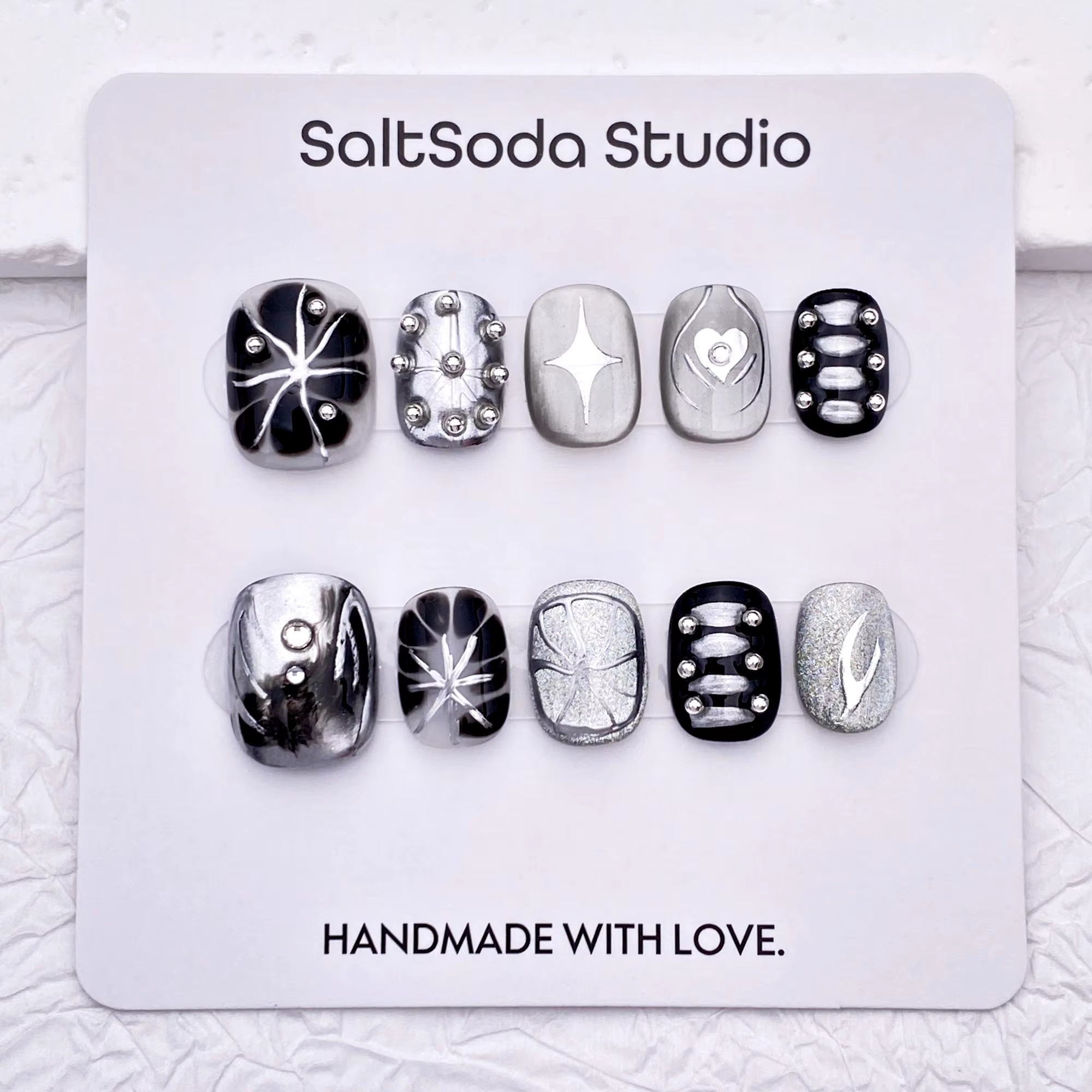 Ongles press-on faits main sur le thème des étoiles gothiques ; style "sweet-meets-cool" avec des st