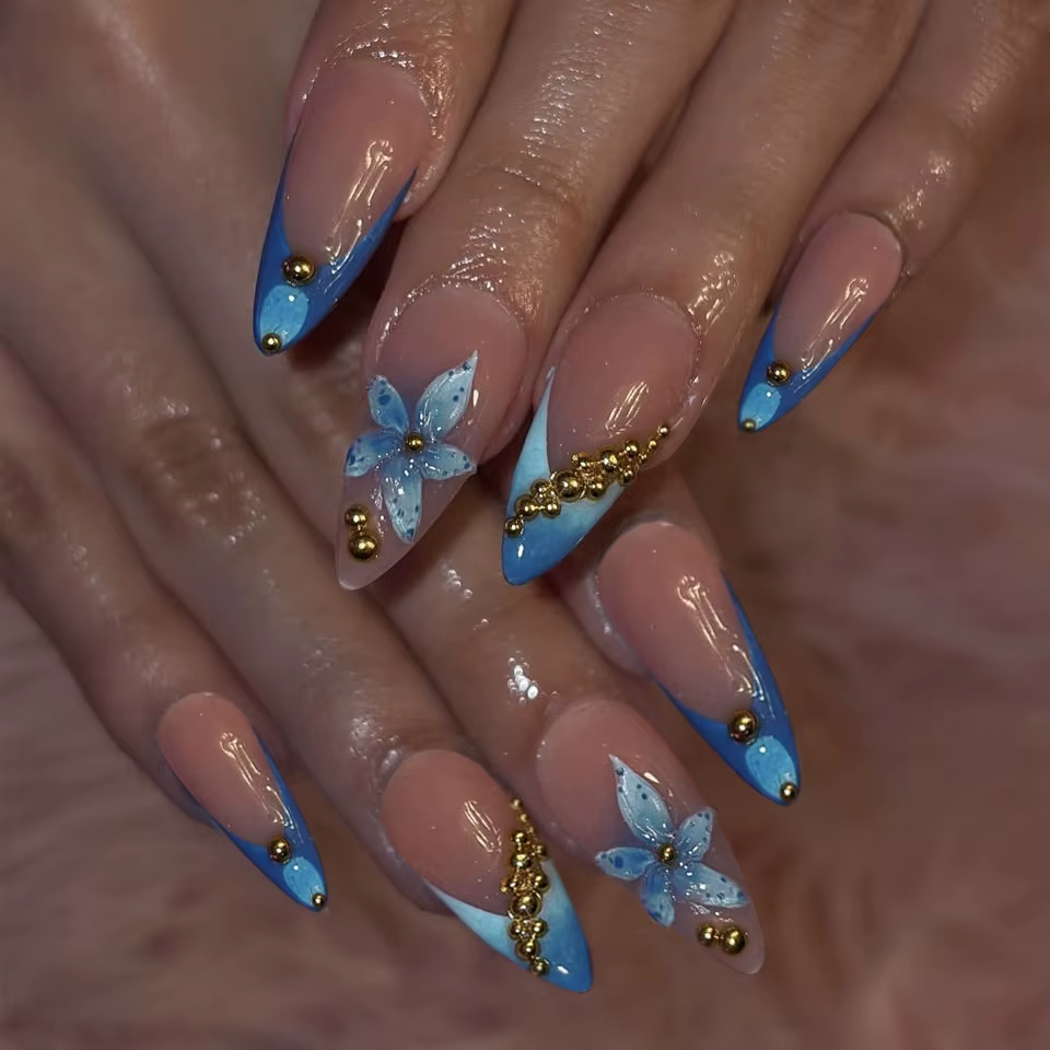 Faux ongles nude avec motif floral rose et bleu, perles métalliques et strass, forme amande, à press