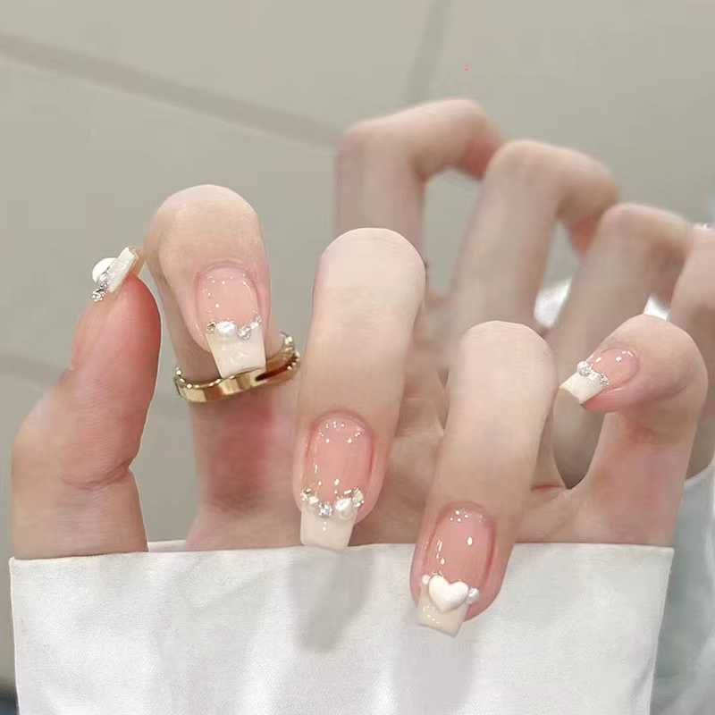 Faux ongles courts en press-on jaune crème style ballerine avec perles blanches et strass