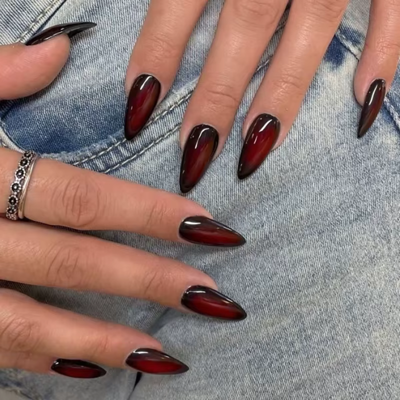 Presse gothique rouge foncé sur les ongles