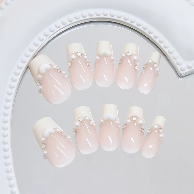 Faux ongles courts en press-on jaune crème style ballerine avec perles blanches et strass